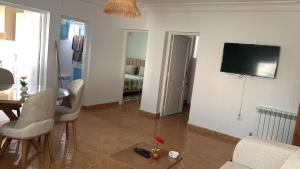 a living room with a table and a tv on a wall at honey moon zeinbe 4 in Hammamet