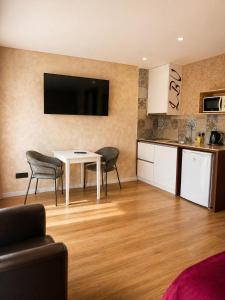 a living room with a table and chairs and a kitchen at Lounge Inn Guest House in Porto