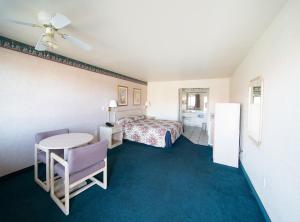 a hotel room with a bed and a table at Superior Suites Phoenix Mesa in Mesa