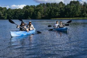 a group of people in kayaks on a lake at Villa nad Kalwą in Tylkowo