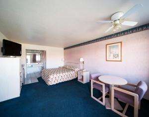 a hotel room with a bed and a table at Superior Suites Phoenix Mesa in Mesa