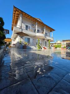 a building with an umbrella on a rainy street at Vila Soleil in Vlorë