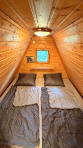 a bedroom with two beds in a wooden cabin at Chata Sekule in Sekule
