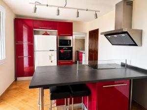 a kitchen with red cabinets and a black counter top at La Grange Blanche in Sault-de-Vaucluse