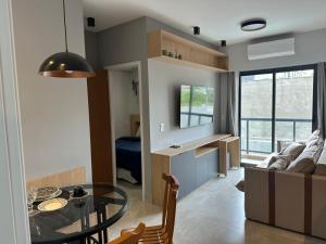 a kitchen and living room with a glass table at Flat Portal Premium Vinhedo in Vinhedo