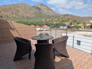 a patio with a table and chairs and a mountain at Hotel Strela Tarrafal in Tarrafal