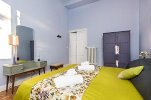 a bedroom with a yellow bed with towels on it at Casa Minerva Al Pantheon in Rome