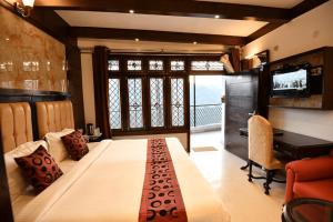 a bedroom with a large bed and a desk at Hotel Morning Lake in Nainital