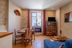 a living room with a table and a tv at Maison - Le Petit Bussac in Aigne
