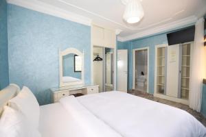 a bedroom with a white bed and a blue wall at Villa d'exception - Piscine à débordement - Vue sur la mer - Barbecue - Salle de sport - Jusqu'à 12 personnes in Feddane Chappo +47 photos