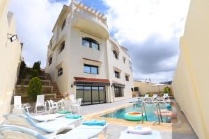 a house with a swimming pool next to a building at Villa d'exception - Piscine à débordement - Vue sur la mer - Barbecue - Salle de sport - Jusqu'à 12 personnes in Feddane Chappo
