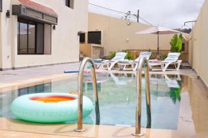 a swimming pool with a pool noodle in a house at Villa d'exception - Piscine à débordement - Vue sur la mer - Barbecue - Salle de sport - Jusqu'à 12 personnes in Feddane Chappo