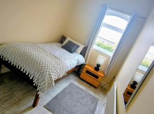 a small bedroom with a bed and a window at Kates coastal cottage in Aillemore