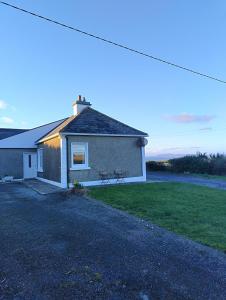 a house with a bench on the side of it at Kates coastal cottage in Aillemore