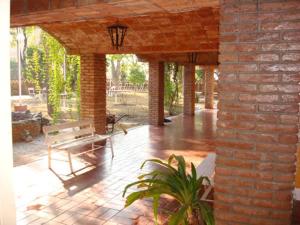 um pátio com um banco e uma parede de tijolos em Grand Hotel by MH em Termas de Rio Hondo