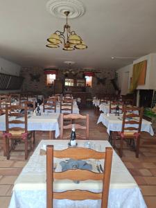 a dining room with white tables and wooden chairs at Logis Hotel Restaurant Mas de la Prairie in Le Vigan