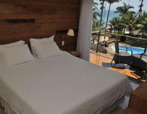 a bedroom with a bed and a view of a pool at Rio Búzios Boutique Hotel in Búzios +68 photos