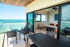 a living room with a table and chairs at Ocean's Embrace and unforgetful sunsets in Progreso