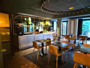 a restaurant with tables and chairs and a kitchen at Paris Porte de Versailles - ISSYHOST in Issy-les-Moulineaux