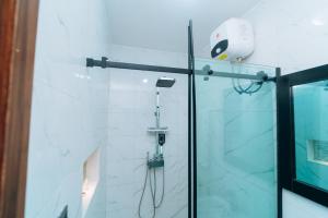 a shower with a phone on a glass door at VHS Vinchee Suites II in Lagos +28 photos