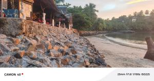 a picture of a rock wall next to a beach at Piscine bimoko in Nosy Be
