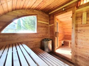 an empty bench in a wooden cabin with a window at Villa nad Kalwą in Tylkowo +50 photos