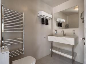 a bathroom with a sink and a toilet and a mirror at Bellevalia Hydra in Hydra +43 photos