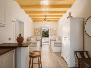 a living room with white walls and a wooden ceiling at Bellevalia Hydra in Hydra