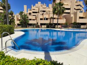 a large swimming pool in front of a building at Bahia De La Plata Seafront in Estepona