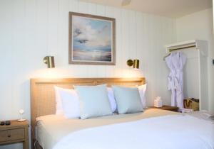 a bedroom with a large white bed with blue pillows at The Trident Inn in Ogunquit +89 photos