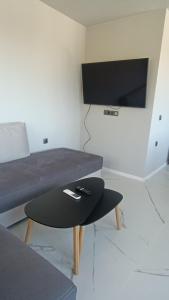 a living room with a couch and a table and a tv at ВЕСЕЛА ВАКАНЦИЯ Китен in Kiten