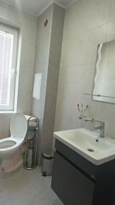 a white bathroom with a toilet and a sink at ВЕСЕЛА ВАКАНЦИЯ Китен in Kiten +34 photos