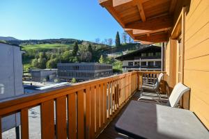 a balcony with a table and chairs and a view at Appartementhaus Kristall incl Joker Card by All in One Apartments in Saalbach-Hinterglemm