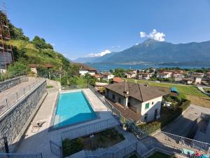a house with a swimming pool and mountains in the background at Immobillario - Casa Luna in Domaso