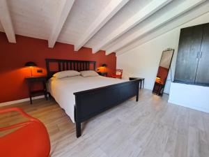 a bedroom with a large bed and red walls at Immobillario - Casa Luna in Domaso