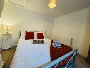 a bedroom with a large bed with red and blue pillows at Scotch Terrace - 3 Bedrooms - Sleeps 6 in Whitehaven