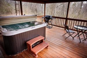 a hot tub on a deck with a table and chairs at Buckeye Bungalow in Logan +17 photos