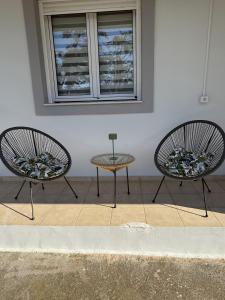 two chairs and a table in front of a building at Archanes Cozy Retreat in Archanes