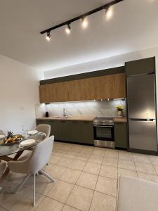 a kitchen with a table and a stainless steel refrigerator at Archanes Cozy Retreat in Archanes