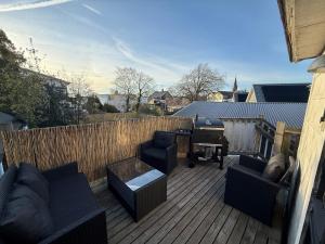 a patio with couches and a grill on a wooden deck at Spacious flat 15 min to the beach in Falkenberg