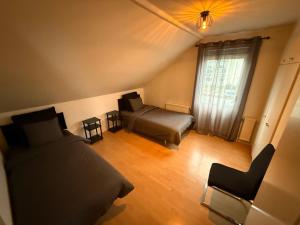 a bedroom with a bed and a couch and a window at Spacious flat 15 min to the beach in Falkenberg