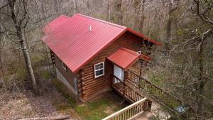 a log cabin with a red roof in the woods at Buckeye Bungalow in Logan