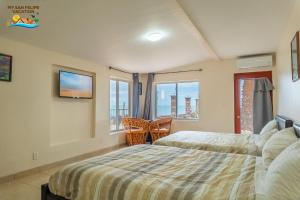 a bedroom with a bed and two chairs and a window at Rancho Percebu Beach Studio 4 in San Felipe