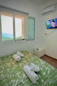 a bedroom with a bed with two towels on it at VILA ELEZI Piqeras in Borsh