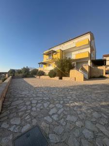 a house with a stone driveway in front of it at Maris Loft Šimuni in Šimuni