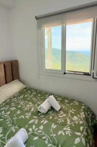 a bed with two towels on it in a room with a window at VILA ELEZI Piqeras in Borsh