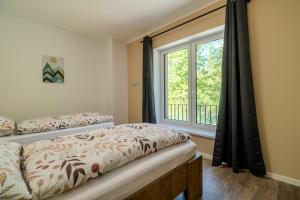 a bedroom with two beds and a window at Ubytování U Lesíka in Znojmo