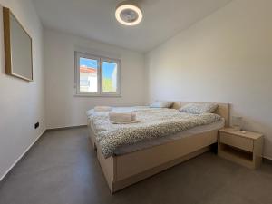 a bedroom with a bed and a window at Maris Loft Šimuni in Šimuni