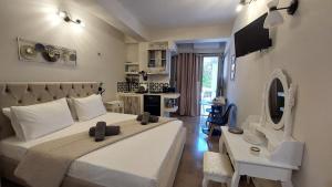a bedroom with a large white bed and a desk at NESTOR LUXURY Studios in Vathi