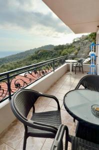 a balcony with a table and chairs and a view at VILA ELEZI Piqeras in Borsh
